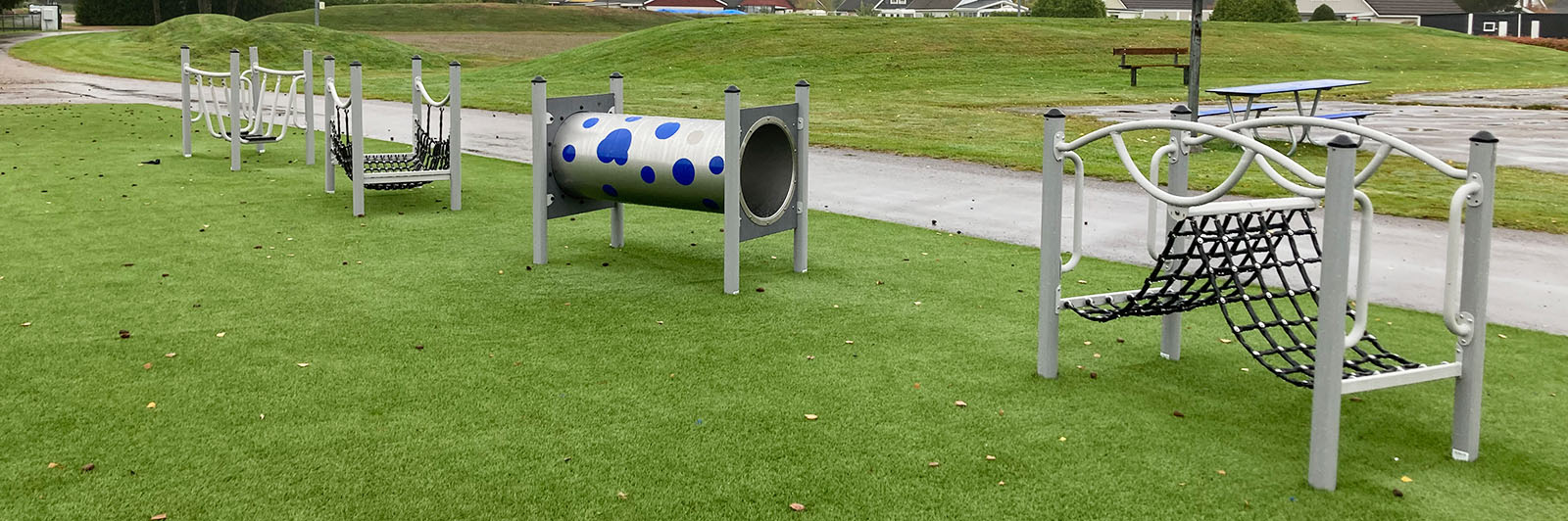 A metal obstacle course made for toddlers at a playground.